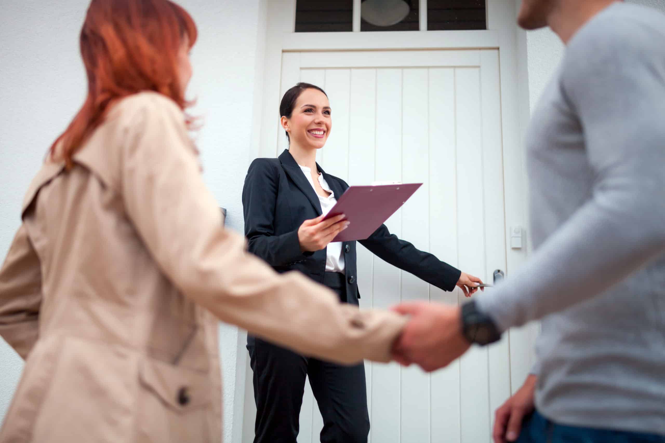 Realtor walk through the door with a couple