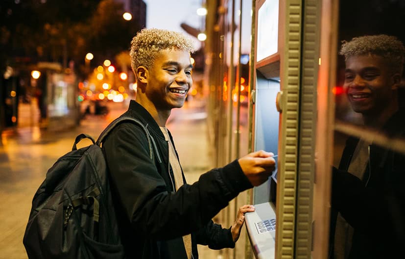 Young man uses his card at the Columbia Heights Lafayette Federal Credit Union ATM