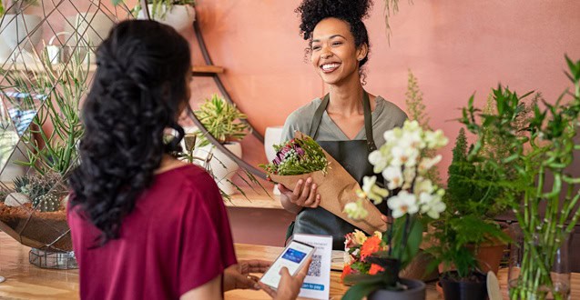 Happy friendly florist giving fresh bouquet to customer