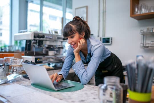 happy woman barista using laptop for take order from customer.